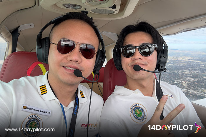 Flight instructor and student smiling in cockpit selfie during training flight